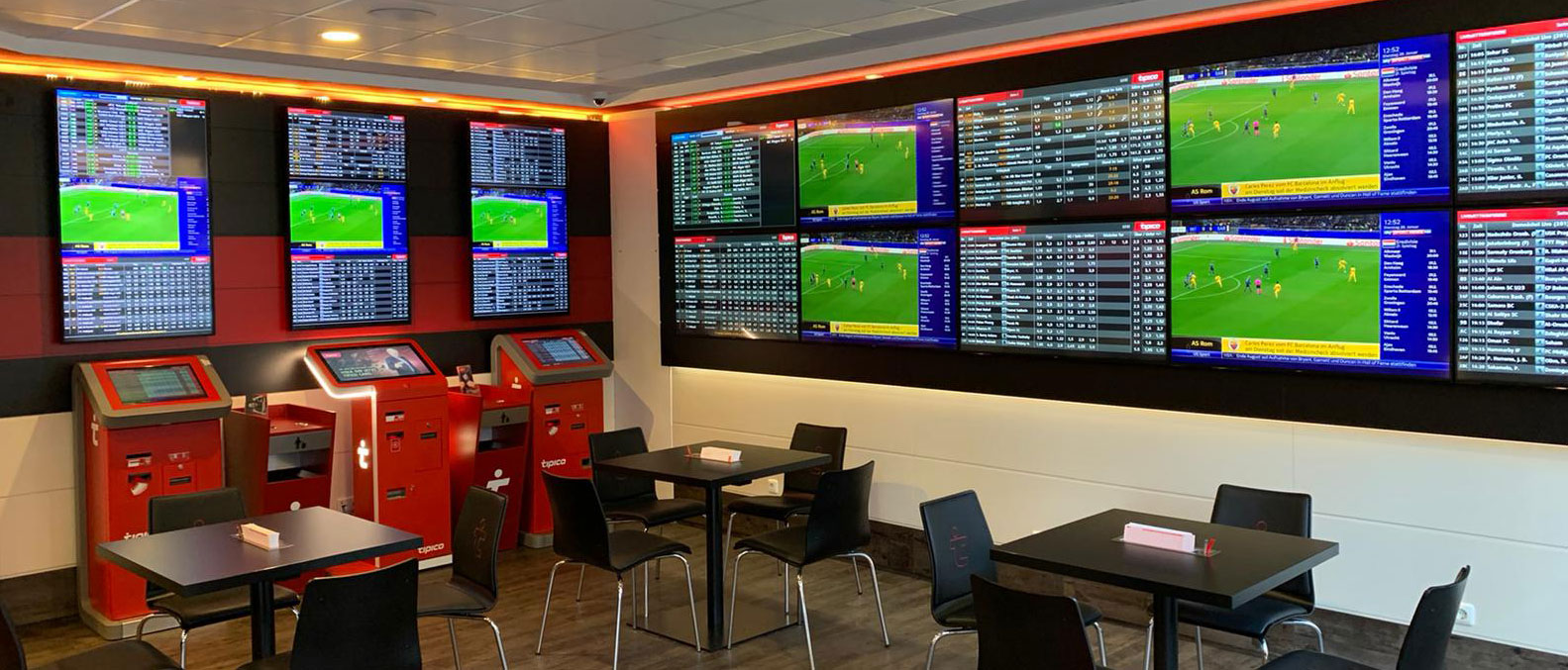 Tipico Wettbüro mit Wettterminals und Quotenanzeigen